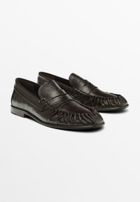 Brune læder loafers med en tekstureret overflade, der har et plisseret tådesign og en flad sål. Enkel, minimalistisk stil.