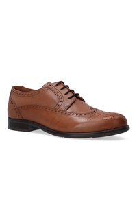 Bruine leren veterschoen met geperforeerde details, ronde neus en een gladde afwerking. Heeft een lage hak en een contrasterende zwarte zool.