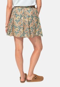 Jupe à motifs floraux dans des couleurs pastel avec des tons verts, jaunes et oranges. Taille élastique, design évasé et tissu léger.