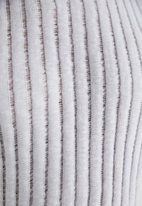 Light gray ribbed fabric with vertical lines, featuring contrasting darker thread accents. Textile has a soft, textured appearance.