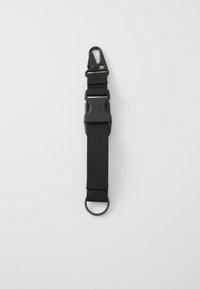 Black nylon strap with a plastic buckle, metal clip, and circular loop. Flat design with a textured surface. Suitable for various attachments.