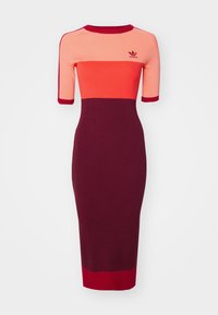 Stickad klänning med korta ärmar, med färgblock i korall, orange och burgunder. Ribbstruktur, rund halsringning, med logodetalj.