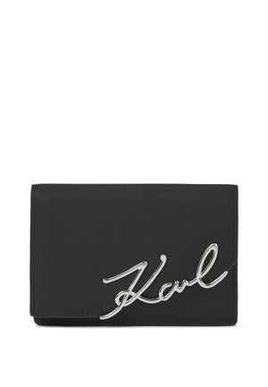 Portefeuille en cuir noir avec une texture douce, doté d'un accent en argent brillant. Forme rectangulaire compacte avec un design plié.