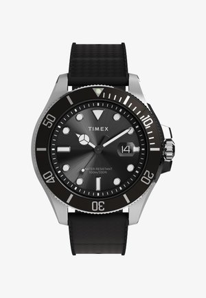 Timexi kell musta tekstuuriga kummirihma, hõbedase korpuse, musta sihverplaadi, helendavate näppude ja 100 m veekindlusega.