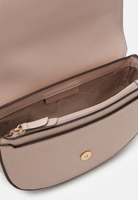 Beige leren handtas met een afgeronde vorm, voorzien van een ritssluiting en gouden hardware accenten. Het interieur heeft een merklabel en een getextureerde voering.