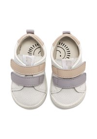 Zapatillas blancas con correas de velcro en gris y beige, con textura perforada, punta redondeada y un divertido estampado de carita sonriente en la plantilla.