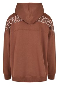 Sudadera marrón con una superficie texturizada, que presenta un estampado en blanco de "URBAN CLASSIC" en la parte superior de la espalda y capucha con cordón.