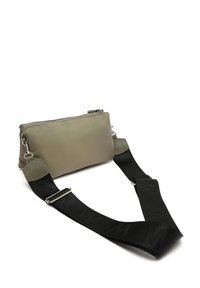 Prostokątna szara torba o gładkiej teksturze, z zamknięciem na zamek błyskawiczny i odpinanym czarnym paskiem w wzór, co zwiększa jej wszechstronność. Akcenty ze srebrnego metalu.