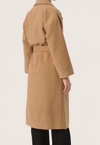 Kamelwoll-Mix-Mantel mit tailliertem Schnitt, langen Ärmeln und Kragen, mit einer schlichten Textur und mittellangem Design.
