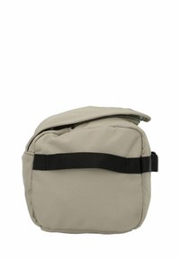 Beige stoffen tas met een rits, voorzien van een zwarte band en een afgeronde rechthoekige vorm. Eenvoudig ontwerp, gestructureerd materiaal.