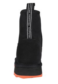 Czarne zamszowe botki za kostkę z teksturowanym wykończeniem, elastycznym bocznym panelem i pomarańczową gumową podeszwą. Posiadają markowy uchwyt z tyłu.