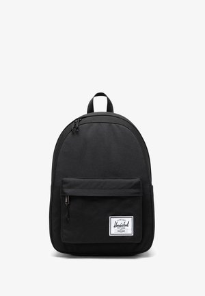 Sort Herschel rygsæk med en lynlåslomme foran og et hvidt logo-patch på en ensfarvet hvid baggrund.