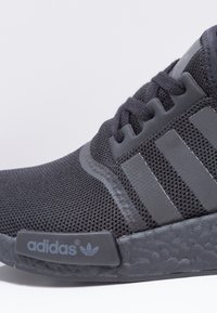 Schwarzer Sportschuh mit Mesh-Obermaterial, drei tonalen Streifen und strukturiertem Gummisohlen. Verfügt über das Markenlogo an der Seite und Schnürsenkel für einen sicheren Sitz.