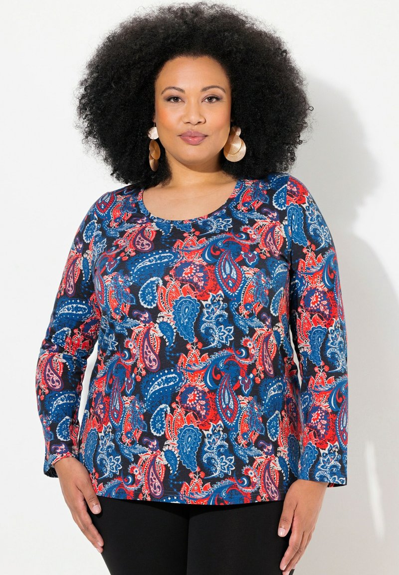 Langarmshirt in Marineblau mit einem Paisleymuster in Rot, Weiß und Blau. Glattes Material mit rundem Ausschnitt und figurnahem Schnitt.