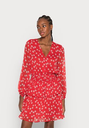 Vestido floral vermelho com decote V profundo, mangas longas, cintura franzida e peplum em camadas. Feito de tecido leve com padrões de flores brancas.