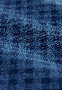 Blaue Karostoff mit strukturiertem Oberflächen, die subtile Farbnuancen und ein gewebtes Muster aufweist. Weicher und leichter Stoff.