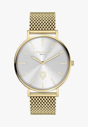 Guldmaske urs med en rund sølv solstråledial, minimalistiske timemarkører og et logo-accent. Har en glat, poleret finish.