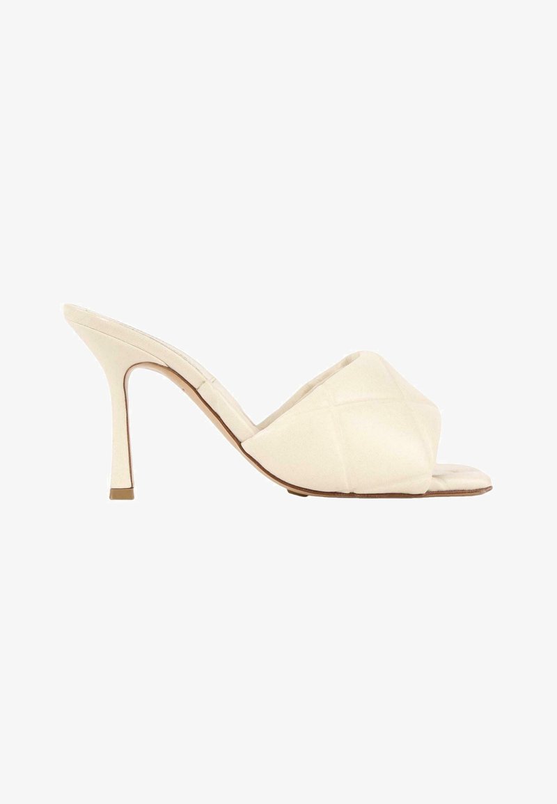 Mule couleur crème à bout ouvert avec empeigne matelassée et talon haut fin, vue de profil.