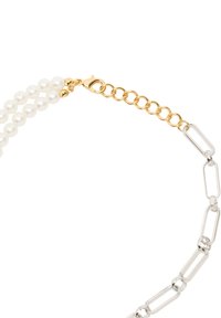 Podwójne perłowe koraliki połączone ze złotym łańcuszkiem z zapięciem typu karabińczyk, połączone z srebrnym, wydłużonym łańcuszkiem owalnym.