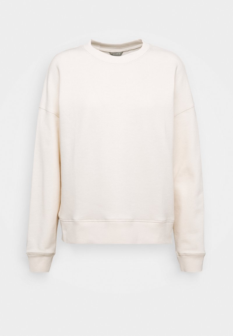 Sweat-shirt uni blanc cassé à col rond, manches longues, poignets et ourlet côtelés, présenté sur un fond gris clair. Aucun motif ou logo visible.