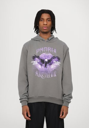 Felpa grigia con cappuccio caratterizzata da un design grafico con testo viola e un'illustrazione di un'aquila contro una luna, maniche lunghe e cappuccio con cordoncino.