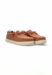 Zapatos de slip-on trenzados en marrón con un upper texturizado, suela de goma beige y detalles de costura claros. Presenta cordones y un interior con patrón.