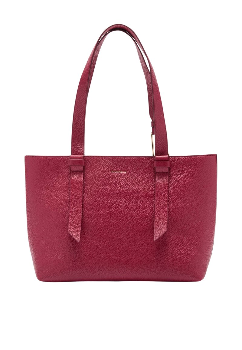 Sac fourre-tout en cuir rouge avec une texture granuleuse, deux poignées plates et un design minimaliste. Présente un logo subtil sur le devant.