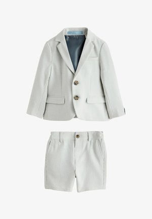 Completo per bambino piccolo grigio chiaro a coste con blazer a due bottoni e pantaloncini abbinati, con tasche frontali e passanti per cintura.