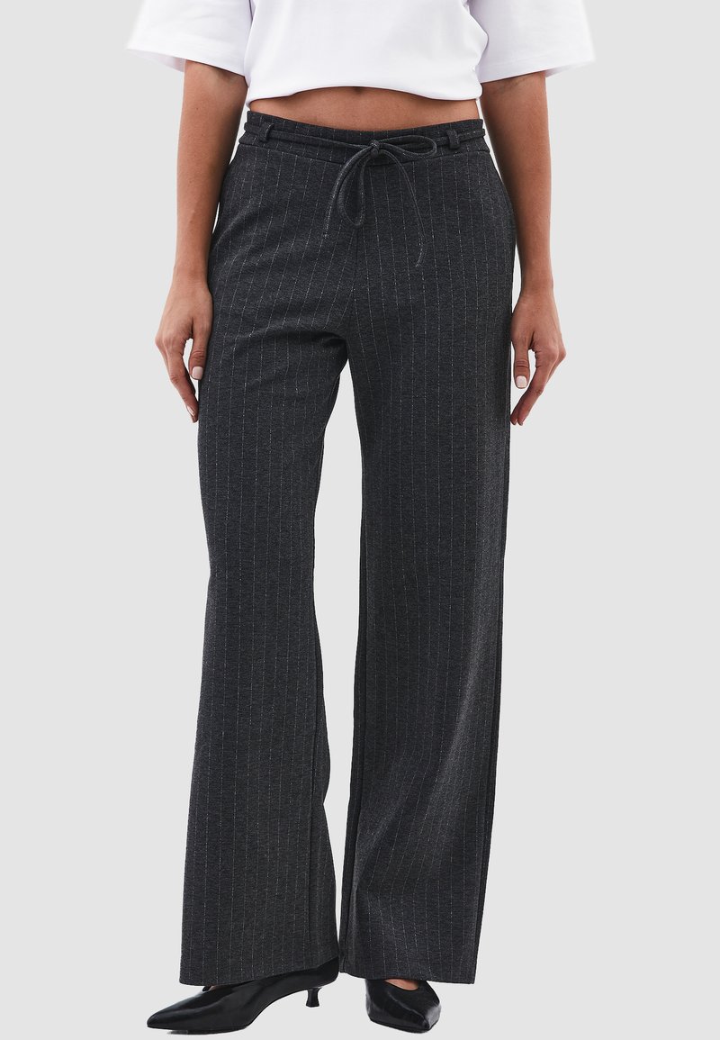 Grijze broek met fijne strepen, gemaakt van een zachte stof, voorzien van een broekband met trekkoord en een wijde pasvorm. Geaccentueerd met subtiele verticale lijnen.