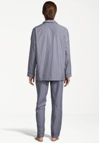 Gestreiftes Schlafanzug-Set in Marineblau und Weiß, bestehend aus langärmeligem Hemd mit Knöpfen und passenden Hosen mit geradem Bein und Umschlägen.