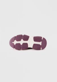 Semelle en caoutchouc violet avec un motif de semelle en zigzag, dotée d'un design texturé et d'accents blancs sur la semelle intermédiaire pour une meilleure adhérence et stabilité.