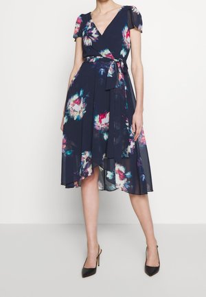 Blumenkleid mit Wickeldesign aus navyfarbener Stoff, kurzen Puffärmeln, taillierten Bindeband, asymmetrischem Saum und mehrfarbigen Blumenmustern.