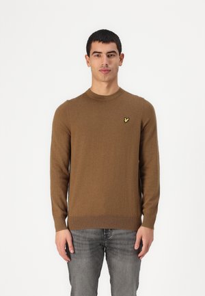 Jersey marrón de manga larga hecho de un tejido suave, con cuello redondo y un pequeño logotipo amarillo en el lado izquierdo del pecho. Acabado texturizado en el dobladillo.