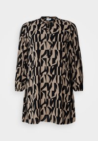 Tunique ample à manches longues, tissu beige avec motif géométrique abstrait noir audacieux, encolure goutte d'eau avec lien.