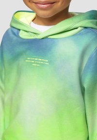 Hoodie met een gradient van blauw naar groen, gemaakt van zachte stof, met een lichtgele bedrukking op de voorkant.