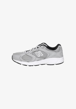 Chaussure de course New Balance grise et blanche avec panneaux en mesh, logo "N" sur le côté, et doublure intérieure noire, vue du côté extérieur.