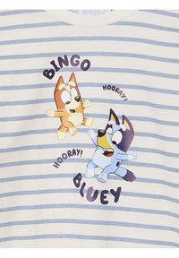 Gestreiftes T-Shirt mit kurzen Ärmeln, das die Cartoon-Hunde "Bingo" und "Bluey" mit verspielten Ausdrücken zeigt. Farbschema: hellblau und Creme.