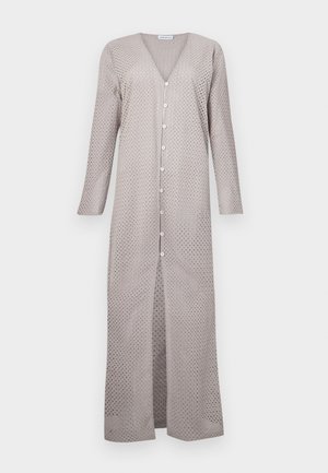 Hellgraues langes Kleid mit V-Ausschnitt, langen Ärmeln und Knopfverschluss. Der Stoff hat ein ausgeschnittenes Punktmuster, eine fließende Silhouette und Seitenschlitze.