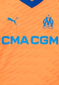 Oranžinė sportinė marškinė su mėlynais akcentais. Turi V formos iškirpimą, Puma logotipą ir didelį mėlyną tekstą "CMA CGM" su sudėtingu raštu audinyje.