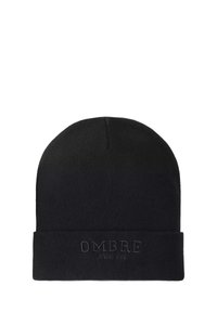 Mustapereinen neulottu myssy, jossa on käännettävä reunus, johon on kohokuviolla painettu "OMBRE" ja "SINCE 1985" -teksti. Pehmeä rakenne ja tiukka istuvuus.