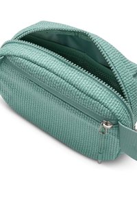 Mint green textured fabric waist bag with two zippered compartments, one partially open showing interior mesh pocket.