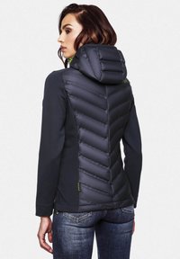 Dark gray jacket featuring a hood, with a padded chevron design and solid fabric sides. Finished with green accents and zippers.