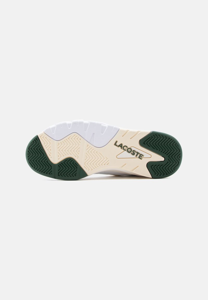 Shoe sole with green and beige rubber grips, white midsection, and "LACOSTE" logo embossed near the arch area.