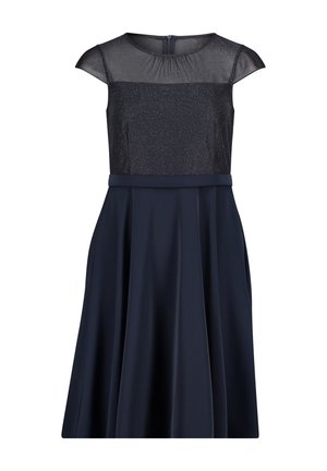 Robe bleu marine avec manches courtes, corsage transparent orné de détails scintillants, taille cintrée et jupe évasée. Fermeture éclair au dos.
