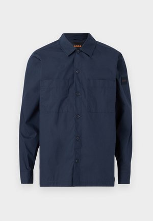 Μπλούζα μακρυμάνικη σε ναυτικό μπλε χρώμα με κουμπιά, δύο τσέπες στο στήθος και γιακά, με μικρή ετικέτα "BOSS" στο αριστερό μανίκι.