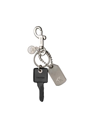 Keychain with a black Calvin Klein key, a metal dog tag engraved with "ck," a small round "ck" charm, and a silver clip hook.