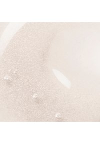 Nærbilde av klar gel med fin glitter og små luftbobler suspendert inni.