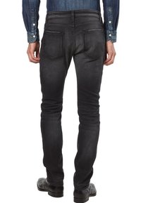 Czarne dżinsy o dopasowanym kroju, wykonane z denimu o wyblakłej fakturze, wyposażone w pięć kieszeni oraz klasyczne zapięcie na guzik i zamek błyskawiczny w pasie.