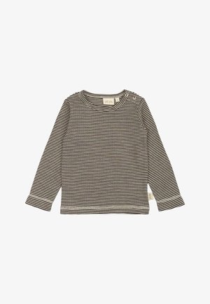 Camisa de manga larga a rayas blancas y negras, hecha de tela suave, con cuello redondo y cierre de presión en el hombro.