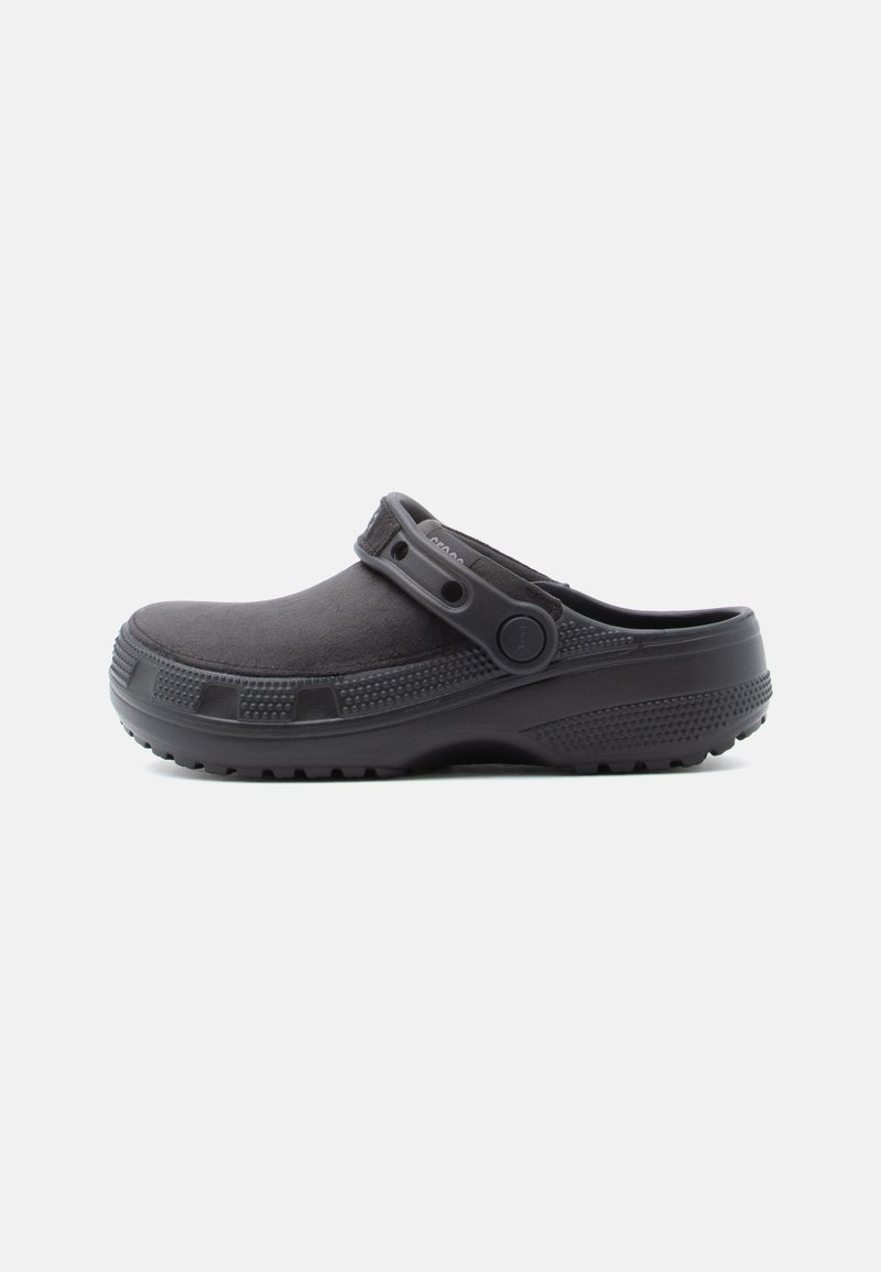 Black slip-on clog with a textured sole and adjustable strap, designed for casual wear and comfort.